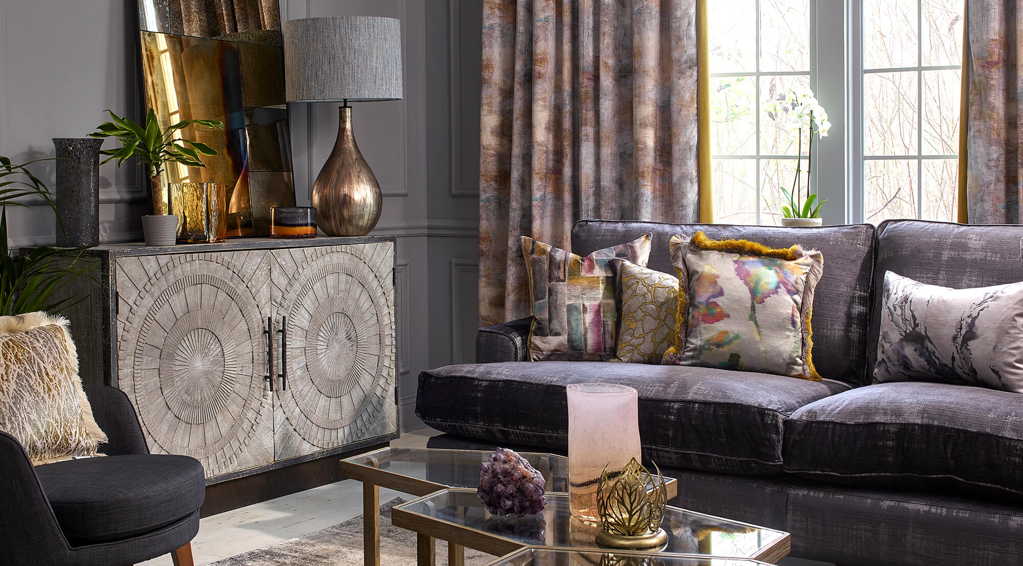 Bespoke sofa, cushions and upholstery in a nicely furnished living room with gold, purple and floral fabrics.